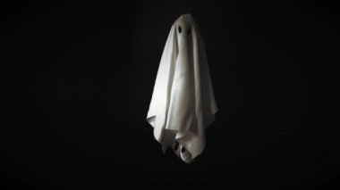 Siyah arka plan ile havada uçan hayalet beyaz levha kostüm Görüntüleri. Minimal Halloween korkutucu kavramı.