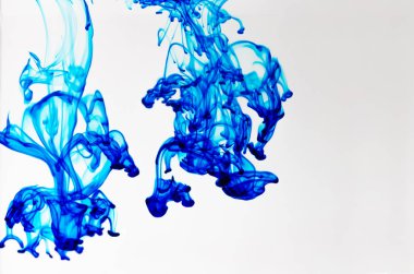 Beyaz arka planda suda mavi gıda rengi damla.