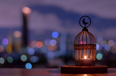 Lantern that have moon symbol on top put on wooden tray with dusk sky and city bokeh light background. Islamic new year concept. clipart