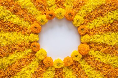 Decorative yellow and orange color marigold flowers and petals rangoli for Diwali festival with white space background.