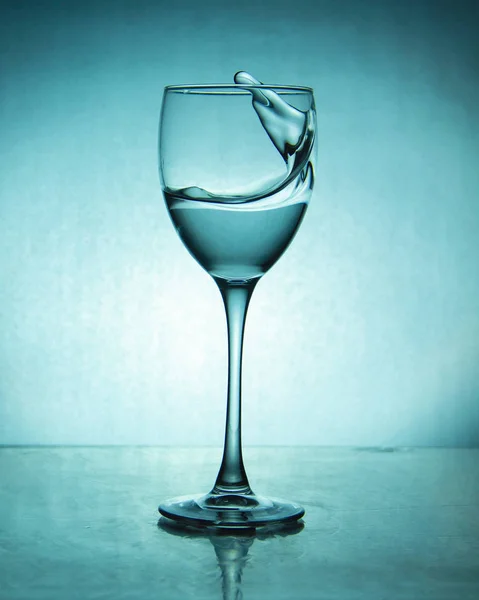 luxury splash drink in a glass on a high leg on a colored background