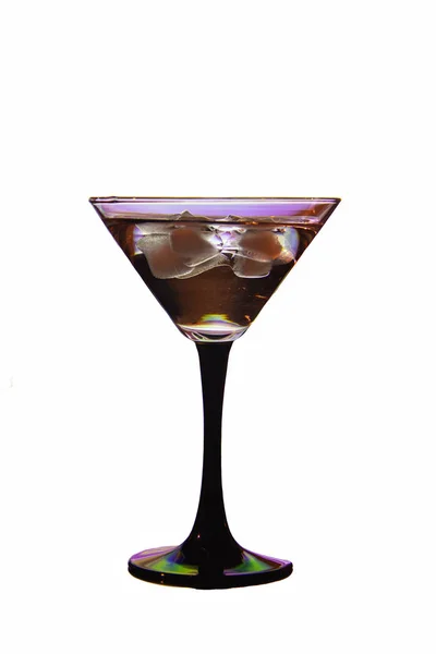 Vackert glas på ett svart ben med en cocktail och is — Stockfoto