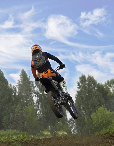 Kompetitif di kompetisi motocross melompat dari batu loncatan pada sepeda motor — Stok Foto