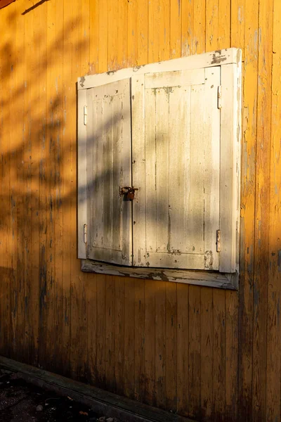 White shutters on a yellow house. Closed window. — Stock Photo, Image