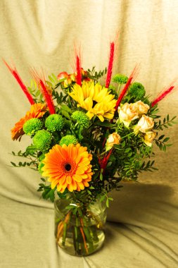 Gri arkaplandaki vazoda farklı renklerde güzel buketler.