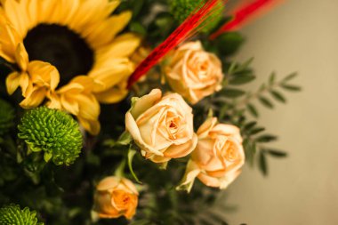 Gri arkaplandaki vazoda farklı renklerde güzel buketler.