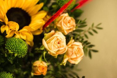 Gri arkaplandaki vazoda farklı renklerde güzel buketler.