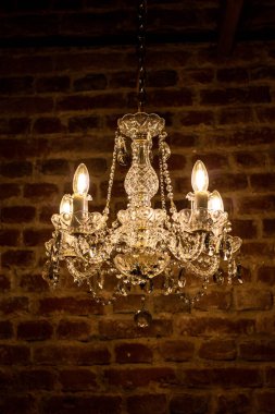 Kristal avize, arkadaki kahverengi tuğla duvarda antik lamba.. 