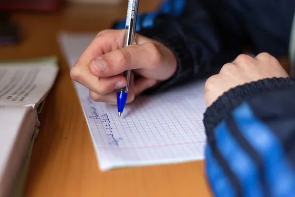 Çocuk bir deftere yazıyor. Çocuk ev ödevi yapıyor. Kalem ve defter. 