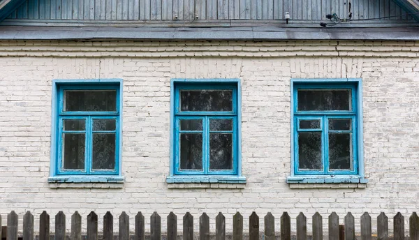 Drei blaue Fenster in einem Backsteinhaus — Stockfoto