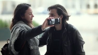 Paltolu mutlu turistler şehirde dikiliyor.