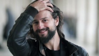 Dışarıda dikilen neşeli genç Latin adam.