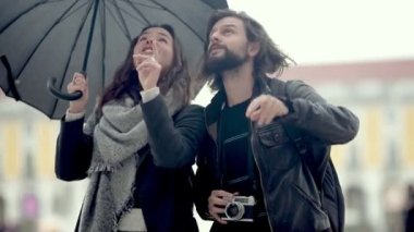Şemsiyeli ve fotoğraf makineli iki turist.