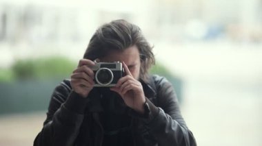 Fotoğraf makinesi kullanan yakışıklı sakallı adam.