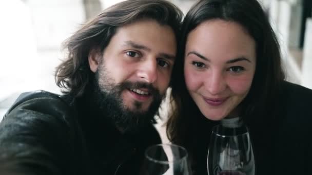 Видеоселфи счастливой молодой пары, сидящей за столом в кафе — стоковое видео