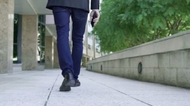 Asfaltta yürüyen erkek bacaklarının arka görüntüsü