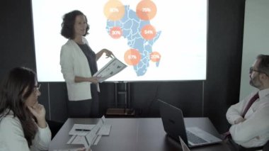 Başarılı kendinden emin kadın, projeyi meslektaşlarına sunuyor.