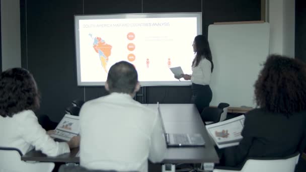 Young businesswoman explaining countries analysis to managers — Stock Video