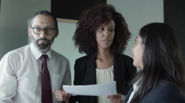 Üç yönetici şirket pazarlama planını tartışıyor