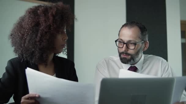 Geconcentreerde ondernemers die documentatie zitten te controleren — Stockvideo