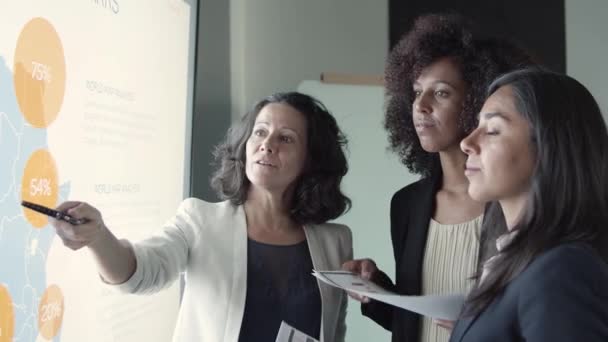 Drei Geschäftsfrauen halten Dokumente in der Hand und diskutieren das Projekt — Stockvideo