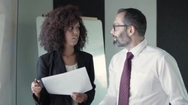 Afrikalı Amerikalı iş kadını elinde kalemle CEO ile konuşuyor.