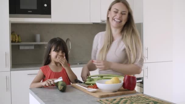Χαρούμενη μαμά κοπής λαχανικών στην κουζίνα — Αρχείο Βίντεο