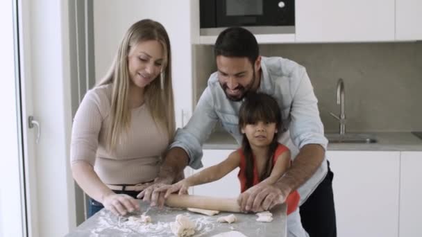 Mamá y papá enseñando a la niña a hornear — Vídeos de Stock