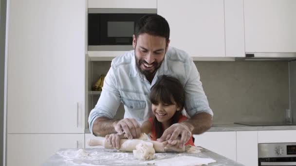 Счастливые папа и маленькая дочь катятся тесто — стоковое видео