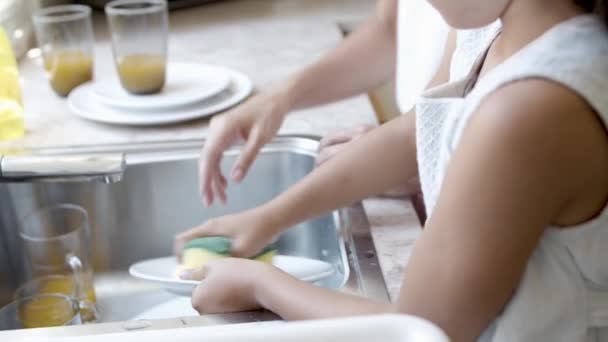 Linda chica ayudando a mamá a lavar el plato — Vídeos de Stock