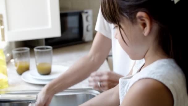 Menina e sua mãe lavar prato juntos — Vídeo de Stock