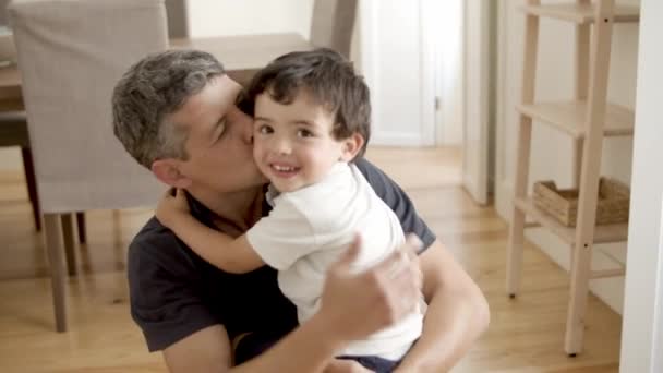 Mutlu baba kucağında küçük oğlunu kucaklıyor ve ona sarılıyor. — Stok video