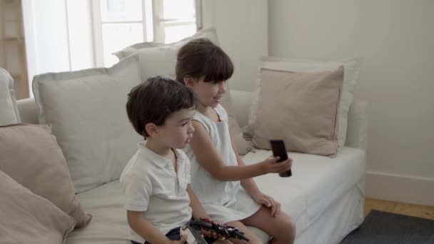 İki küçük çocuk film ya da gösteri izliyor. — Stok video