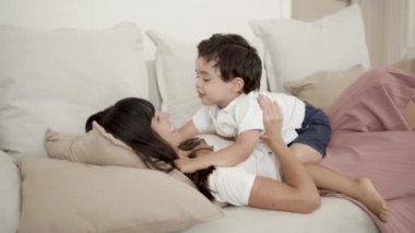 Mutlu anne, küçük oğluyla kanepede geziyor.