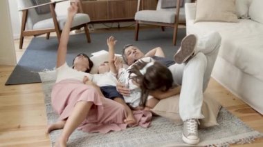 Mutlu bir aile, iki küçük çocuk evde dinleniyor.