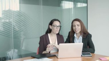 Başarılı bayan meslektaşlar konuşuyor, bilgisayarla görüntülü sohbet ediyor.