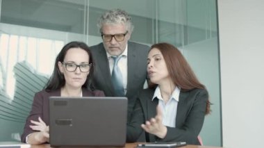 Üç Kafkasyalı ortak dizüstü bilgisayarda projeyi tartışıyor