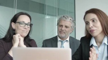 Gülümseyen iş adamları, dizüstü bilgisayarla ortaklarla görüntülü sohbet ediyor