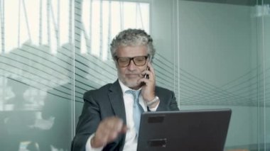 Takım elbise ve gözlük takan ciddi bir iş adamı.