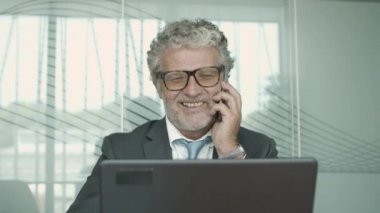 Takım elbise ve gözlük takan olgun bir iş adamı.