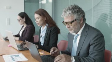 Çalışma arkadaşları birlikte masa başında oturuyorlar.