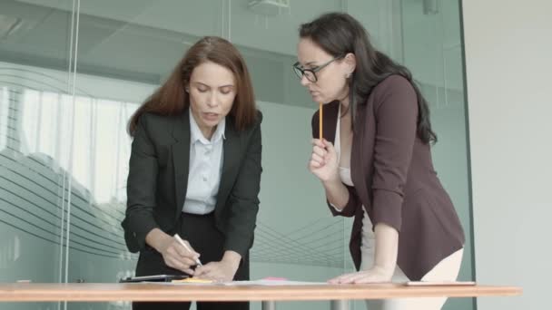 Twee vrouwelijke collega 's die het werk plannen en bespreken — Stockvideo