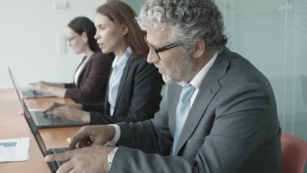 Fila de homem de negócios e mulheres sentados juntos na mesa — Vídeo de Stock