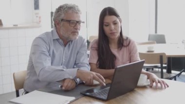 Belgeleri dizüstü bilgisayarla okuyup konuşan kendinden emin işçiler.