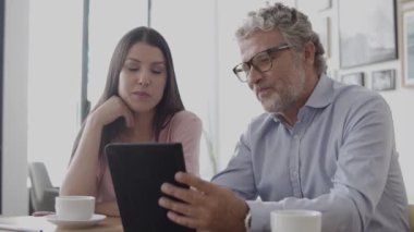 Esmer iş kadını masada oturuyor ve konuşuyor.