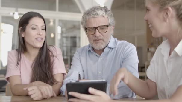 Seniorchef mit Brille schaut etwas auf dem Tablet — Stockvideo