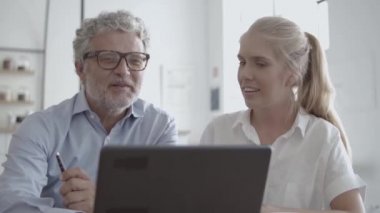 Gözlüklü CEO kadın sekreterle konuşuyor.