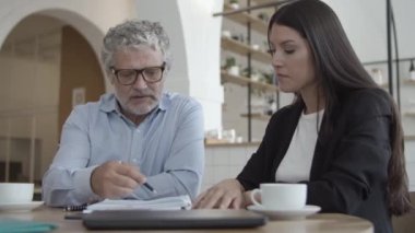 Gri saçlı iş adamı sigorta acentasıyla görüşüyor.