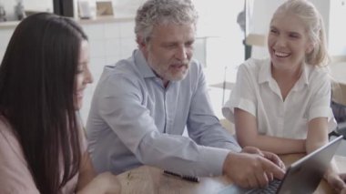 Üst düzey gri saçlı işadamı dizüstü bilgisayarda klavye kullanıyor.