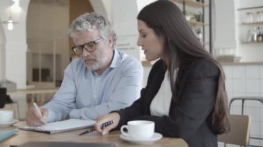 İş ortakları masada fincanlarla oturuyor.